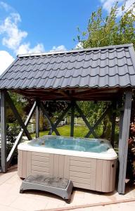 Dinsheim的住宿－Les Papillons de la Bruche，一个带屋顶的凉亭下的热水浴池