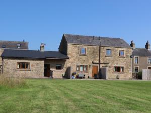a large stone house with a grass field in front of it at The Proven House in Preston