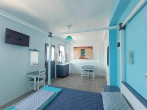 um quarto com uma cama, uma secretária e uma mesa em Anemos Guest House Karpathos em Ólympos