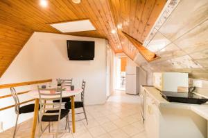 a kitchen and dining room with a table and chairs at AZURE house in Keszthely