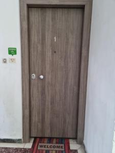 una puerta de madera en un pasillo con una alfombra en The Zen Apartment Athens, en Atenas