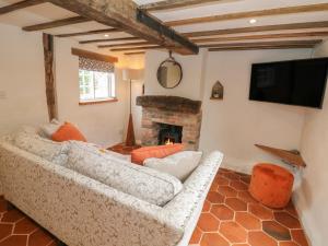 a living room with a white couch and a fireplace at Auld Cottage in Norwell