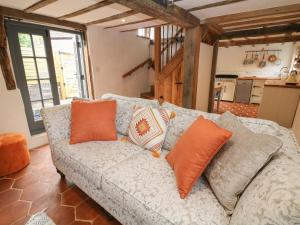 a living room with a couch with orange pillows at Auld Cottage in Norwell