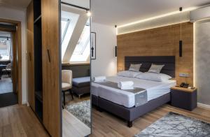 a bedroom with a king sized bed and a desk at Minaret Residence & Relax Pécs in Pécs +52 photos