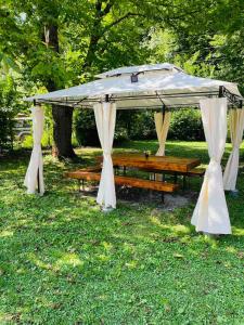 um gazebo com uma mesa e bancos num parque em Къща за гости Станеви em Ribarica