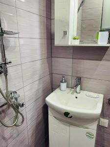 uma casa de banho com um lavatório branco e um espelho. em Къща за гости Станеви em Ribarica