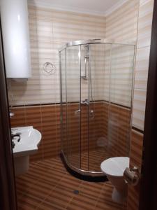 Un baño con ducha, inodoro y lavabo. en Апартамент в MountainLake, en Smolyan