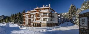 Un gran edificio cubierto de nieve en la nieve. en Апартамент в MountainLake, en Smolyan