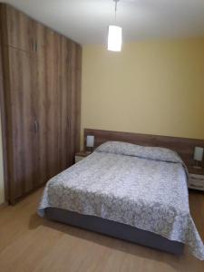 Un dormitorio con una cama y un gran armario de madera. en Апартамент в MountainLake, en Smolyan