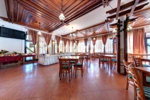 a dining room with wooden floors and tables and chairs at Hotel Kokiche in Sunny Beach