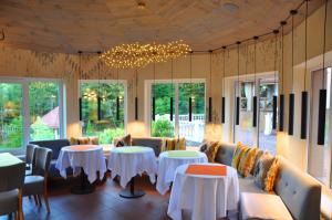 a restaurant with tables and couches and a chandelier at Вiлла Тераса in Polyana