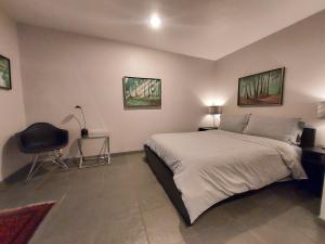 a bedroom with a large bed and a chair at Silver Box Beverly Hills in Los Angeles