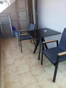 a black table and chairs in a room at Buganvilla Sea View apts in Agia Pelagia