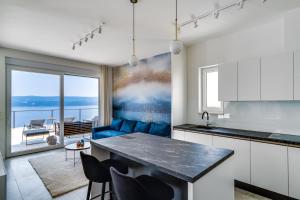 een keuken met een blauwe bank en een tafel bij Seaview Villa Marila with a private pool with hydromassage, 3 en suite bedrooms, 1km from beach in Lokva Rogoznica