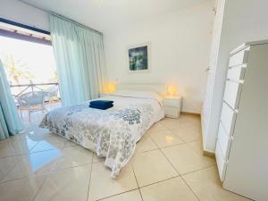 プラヤ・デ・ラス・アメリカスにあるNON Two bedroom apartment in complex Paraiso Royal, LA28の白いベッドルーム(ベッド1台、バルコニー付)