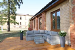 a couch sitting on a deck next to a building at House - conference hall for events in the center of the Daugavpils fortress in Daugavpils