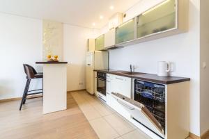 a kitchen with white cabinets and a counter top at Sunny Center Apt, Covered Parking, Balcony & Self Check-in in Kaunas