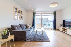 a living room with a couch and a tv at Sunny Center Apt, Covered Parking, Balcony & Self Check-in in Kaunas