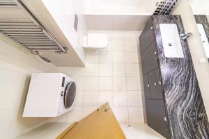a bathroom with a washer and dryer on the wall at Sunny Center Apt, Covered Parking, Balcony & Self Check-in in Kaunas +27 photos