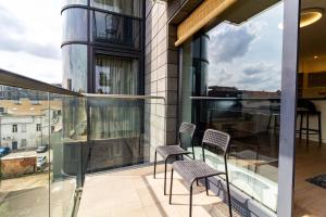 a balcony with chairs and a table on a building at Sunny Center Apt, Covered Parking, Balcony & Self Check-in in Kaunas