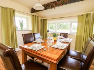 a dining room with a wooden table and chairs at The Cottage at Nidderdale in Harrogate