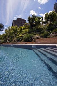 a large pool of water with a house in the background at Gli Appartamenti Di Torre Bertona in Todi