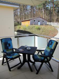 uma mesa e cadeiras numa varanda com vista para um celeiro em Haus Ostseeduo FeWo Nr. 4 em Bansin