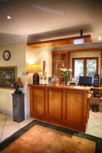 a large room with a desk with a clock on the wall at Auberge de Courtrai in Paarl