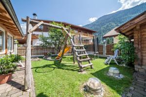 a backyard with a playground with a wooden ladder at Sonnenparadies Apartement 3 in Saltusio