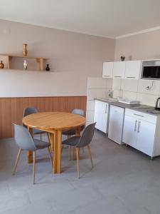 - une cuisine avec une table et des chaises en bois dans l'établissement Apartman Pávai-Silye, à Hajdúszoboszló