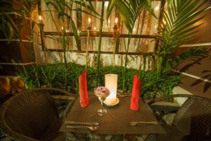 a table with a candle and a glass of wine at Angkor Pearl Hotel in Siem Reap
