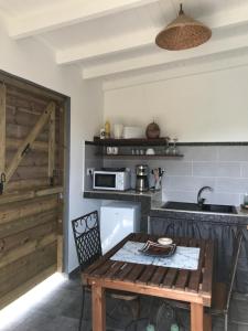 - une cuisine avec une table en bois et un comptoir dans l'établissement LES ALOÈS By CREYOL ANIMAL, à Grand-Bourg