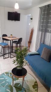 La Suite Odile Piscine في لو لامينتين: غرفة معيشة مع أريكة زرقاء وطاولة