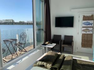 a living room with a couch and a view of the water at Vijverhuis in Ieper