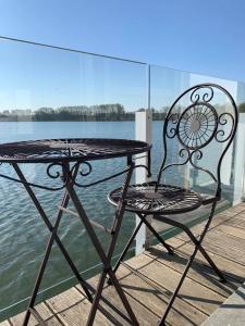 un tavolo e una sedia seduti su un molo vicino all'acqua di Vijverhuis a Ypres