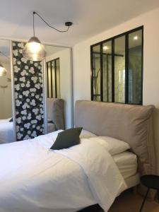 ein Schlafzimmer mit einem weißen Bett und einer Couch in der Unterkunft Ambiance Seine - appartement 46m2 terrasse - Hortensia in Thomery + 18 Fotos