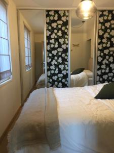 - une chambre avec un lit et un grand miroir dans l'établissement Ambiance Seine - appartement 46m2 terrasse - Hortensia, à Thomery