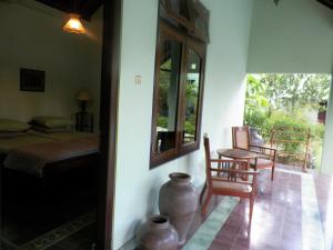 a room with a bed and a table and chairs at Rumah Sawah in Yogyakarta