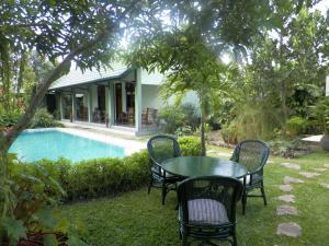 a table and chairs next to a swimming pool at Rumah Sawah in Yogyakarta
