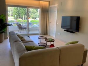 a living room with a couch and a flat screen tv at Jardines del Mar ,Casa Apolonia in Marbella