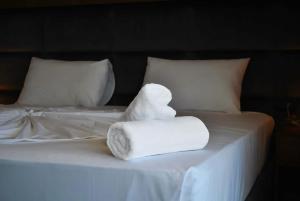 een stapel handdoeken bovenop een bed bij Twin Towers Hotel City & Beach Resort in Shëngjin