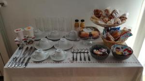 a table with dishes and utensils and baskets of bread at Umbriahouse in Terni