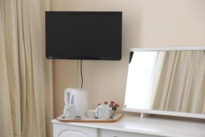 a flat screen tv hanging on a wall next to a mirror at Runnymede Court Hotel in Saint Helier Jersey