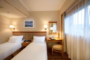 A bed or beds in a room at The Cityview - Chinese YMCA of Hong Kong