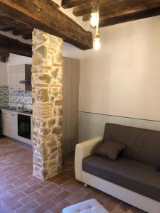 a living room with a couch and a stone pillar at Appartamento Cuore in Montemerano