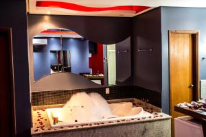 a bathroom with a large mirror and a bath tub at MIRAGEM MOTEL in Rio Verde +28 photos