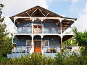 The Nelsbells Cottage في كلارينس: منزل أزرق كبير مع شرفة كبيرة