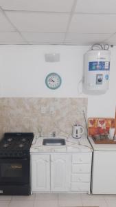 a kitchen with a stove and a clock on the wall at DEPRTAMENTO DONOVAN II in Resistencia