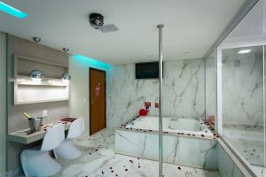a bathroom with a tub and a toilet and a shower at MIRAGEM MOTEL in Rio Verde
