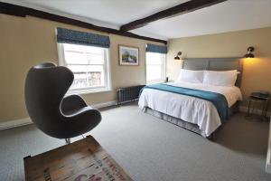 a bedroom with a bed and a chair in it at The Marlborough Dedham in Dedham